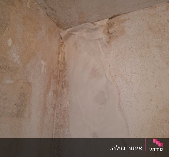 פינה עם כתמי רטיבות וטיח מתקלף